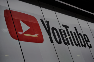 Youtube logo projected onto a screen, with office lights reflected on it